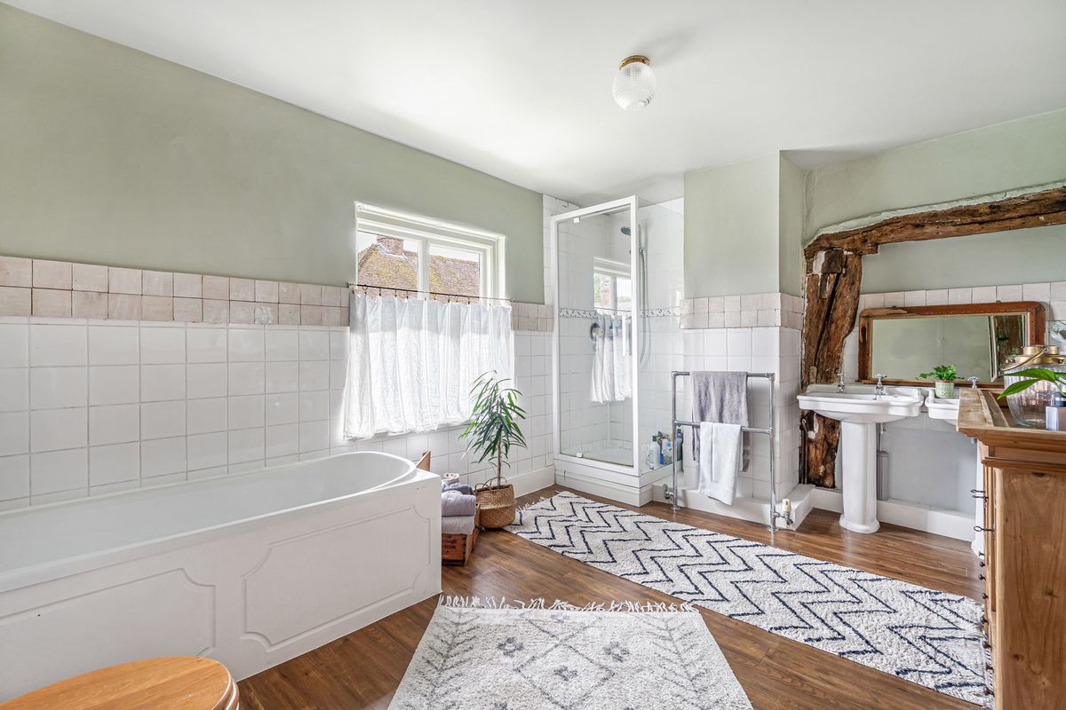 The family bathroom, with a bath, a separate shower and a timber-framed mirror