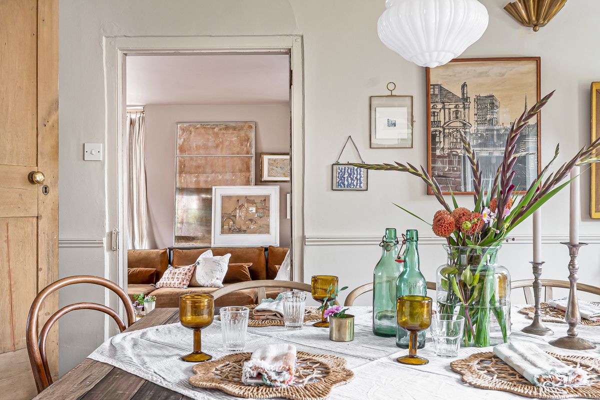 The dining table laid with glass and flowers, the sitting room beyond