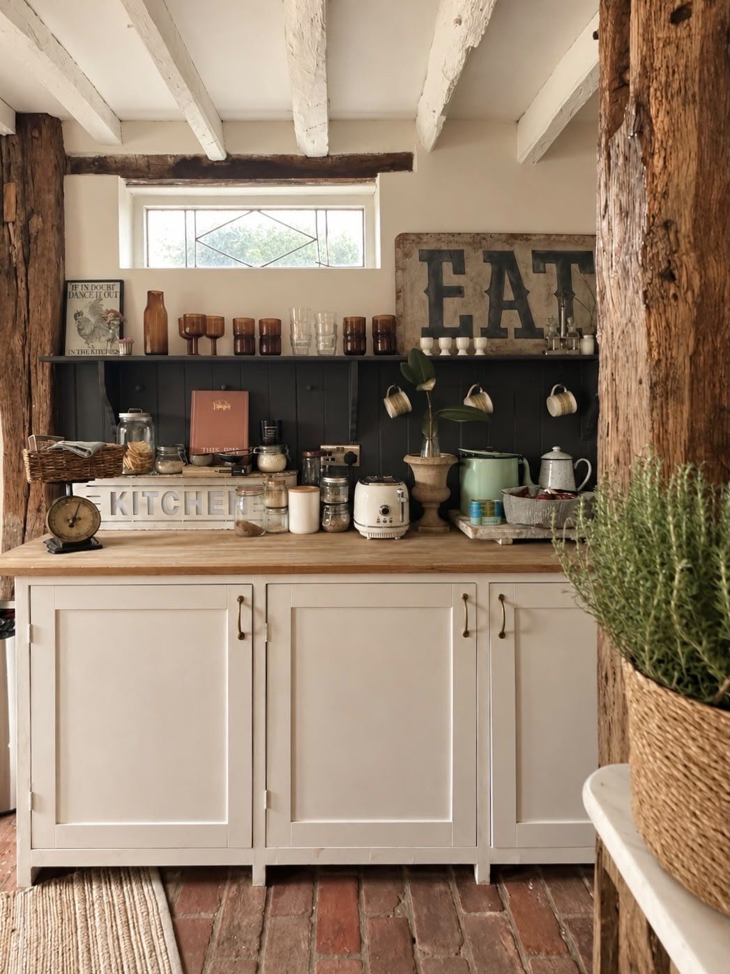 Painted cupboards and open shelving against a dark wall, under white beams