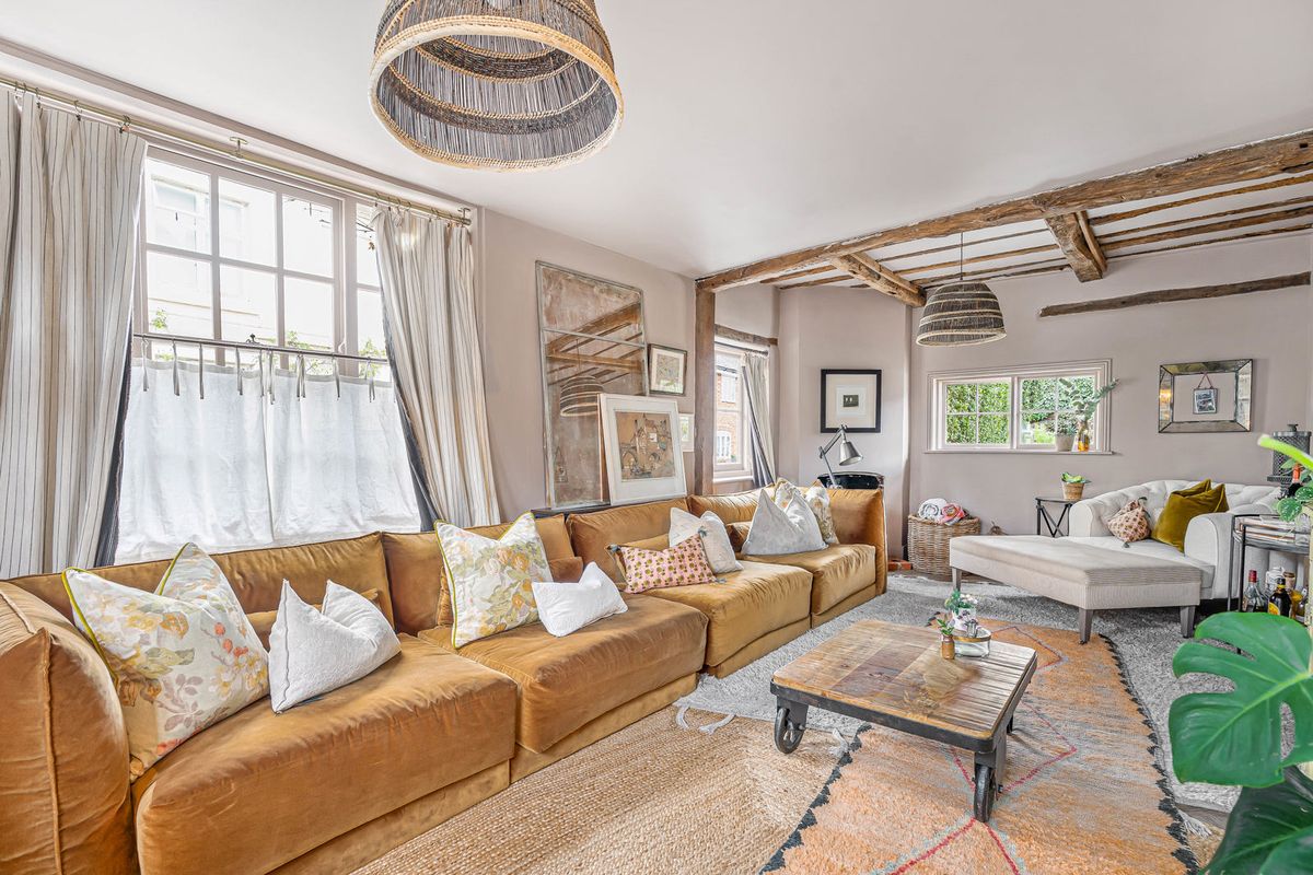 The sitting room looking across to the windows, beams overhead